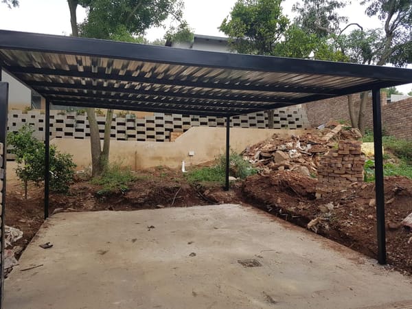 An IBR-roofed carport with a concrete floor, made and installed