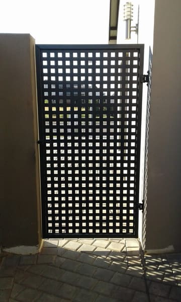A grid-pattern steel gate, made and installed
